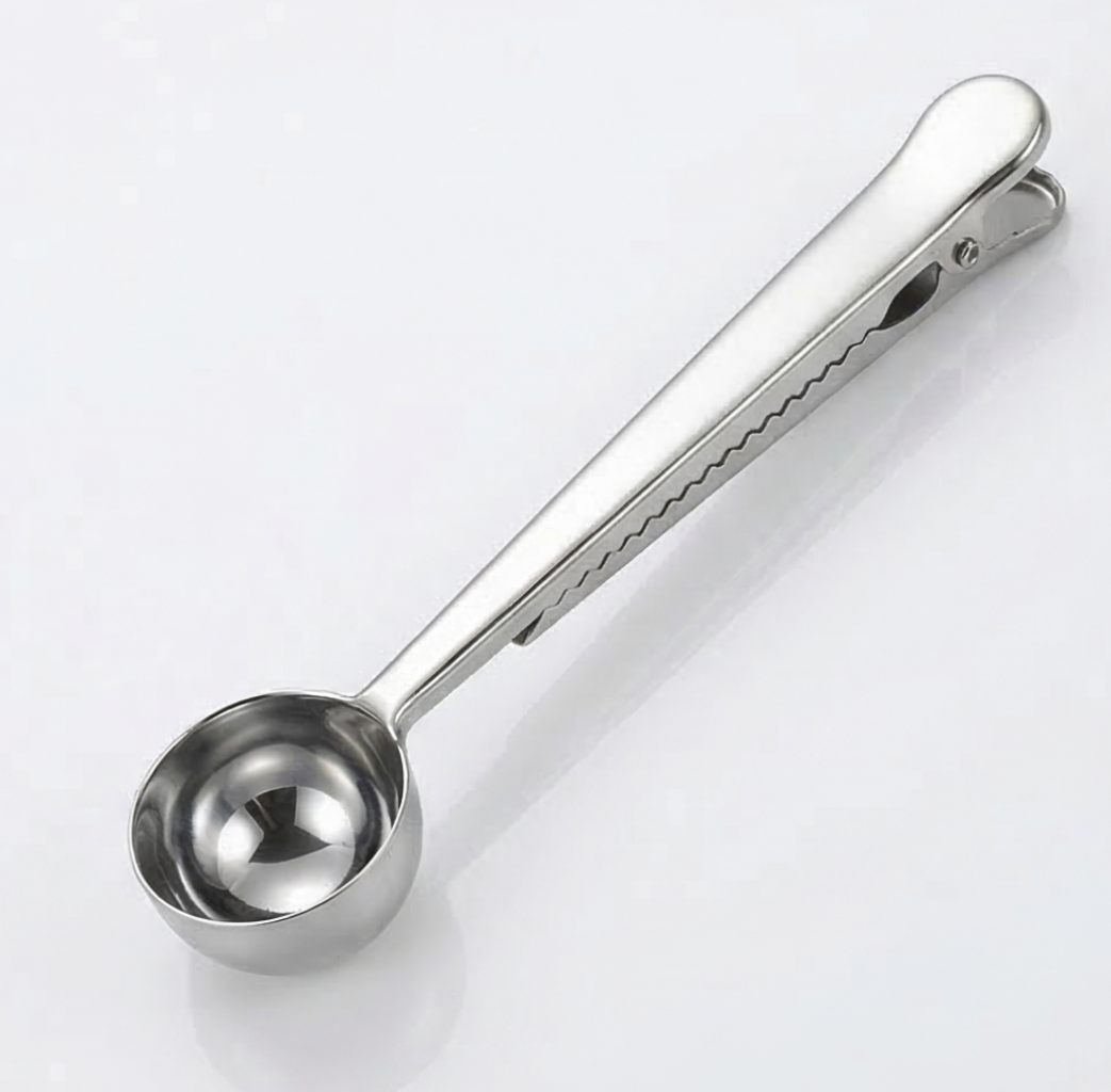 Silver colored measuring spoon on a white background