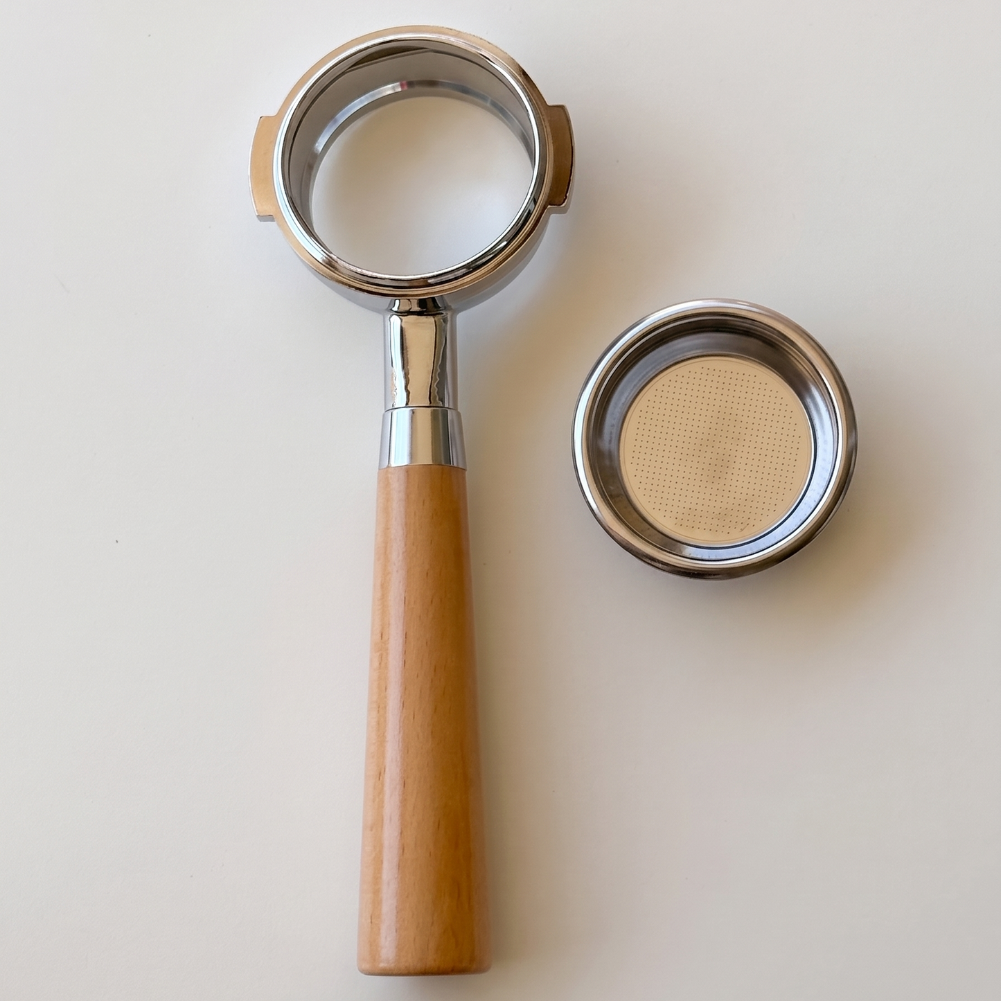 54mm portafilter with wooden handle on a light beige background