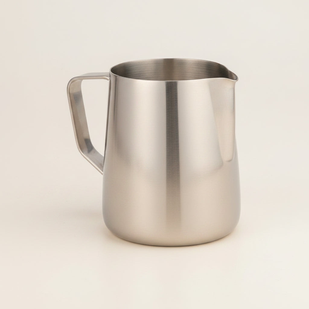 Stainless steel milk pitcher on a white background